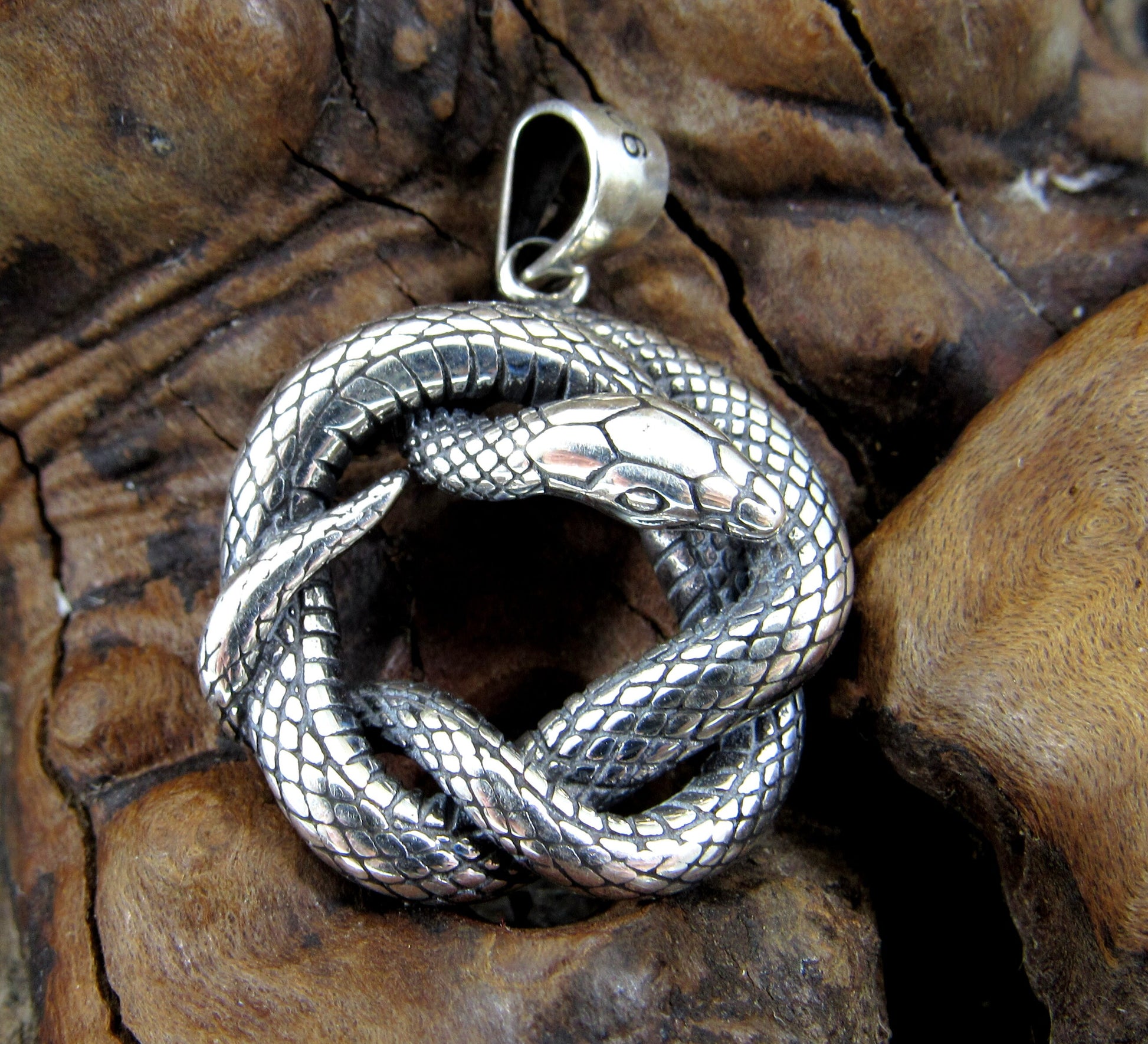 Rattlesnake is interwoven to create a round, 3 dimensional pendant. Handcrafted in solid sterling silver, the snake is highly detailed with scales